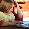 children learning to use computer with parent featured