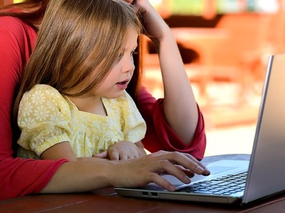 children learning to use computer with parent featured