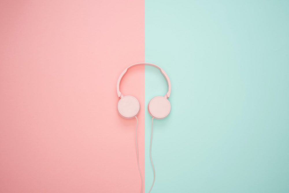 pink headphones on background, wearing headphones at work