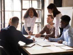 Serious international diverse business team people and african female leader boss discuss financial result review paperwork, being an ally
