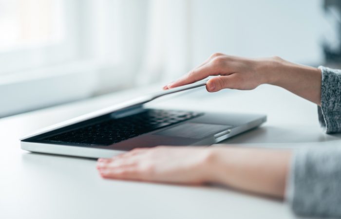 Close-up image of female hands open or close laptop on white table, work-life balance, working from home