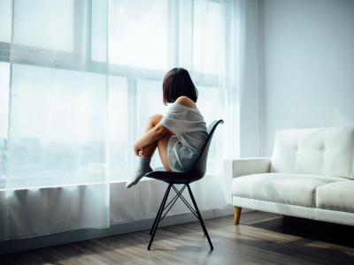woman sat on a chair in the middle of the room, anxierty, mental health