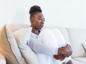 Domestic abuse survivor, sad woman sitting on couch, domestic abuse victim