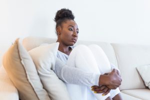 Domestic abuse survivor, sad woman sitting on couch, domestic abuse victim