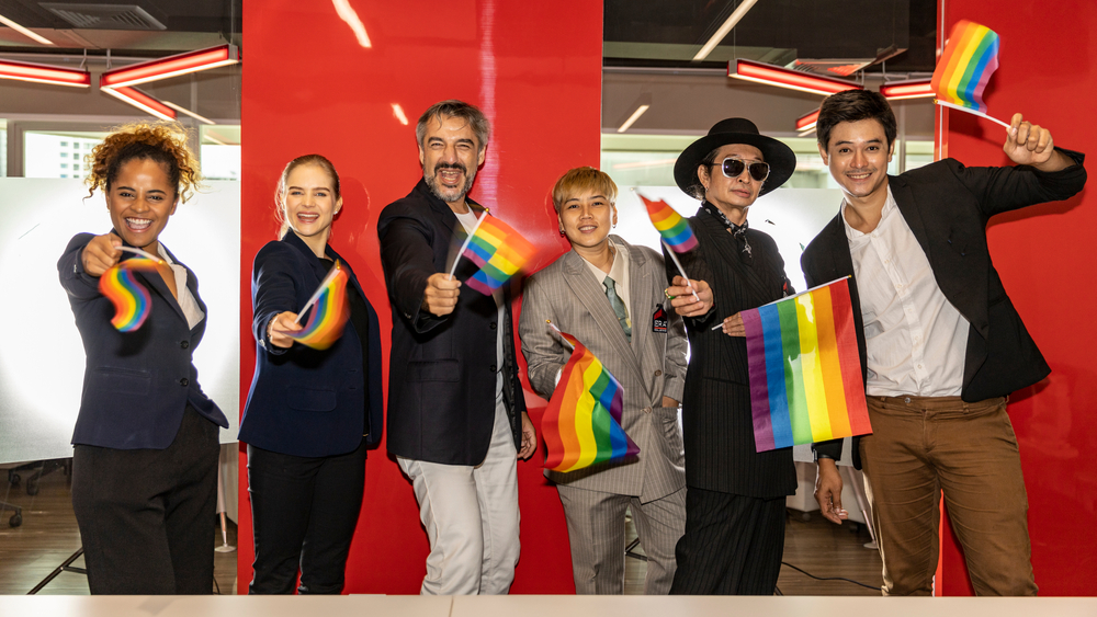 Business people showing LGBT flags in an office, role models