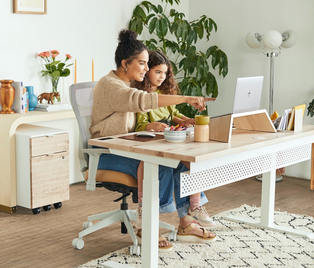 young mum working from home with child, school holidays