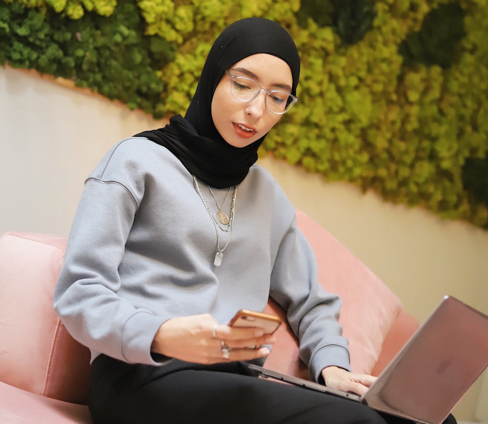 Muslim woman wearing hijab, working on a laptop, career