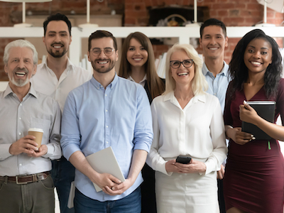 Happy diverse professional business team stand in office looking at camera, smiling young and old multiracial workers staff group pose together as human resource