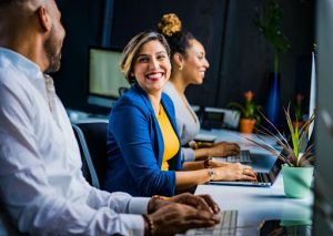 Young woman working in office, smiling with colleagues
