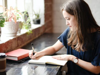 young woman writing in a diary