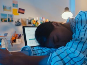 Woman with ADHD sleeping while working from home, burnout