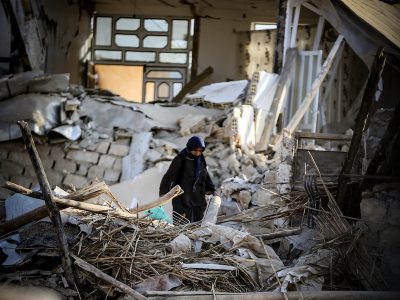Women walking through rubble after earthquake
