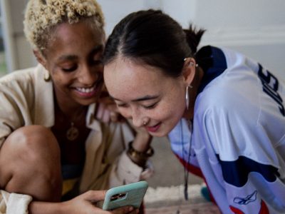 women holding smartphone and smiling, gen z