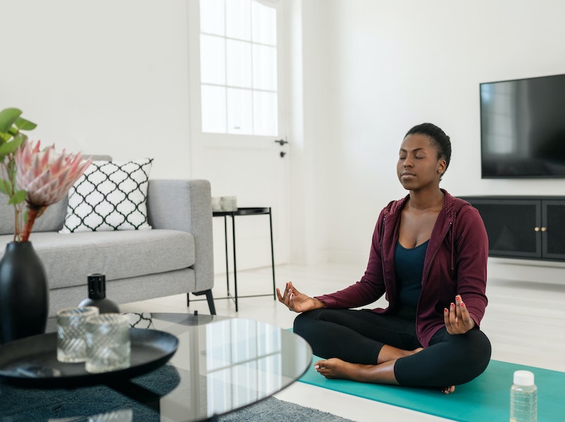 Woman sitting on floor of home practicing morning meditation