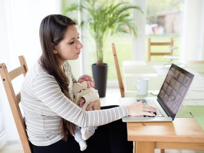 working mum, woman working at home with baby in her arms, returning to work
