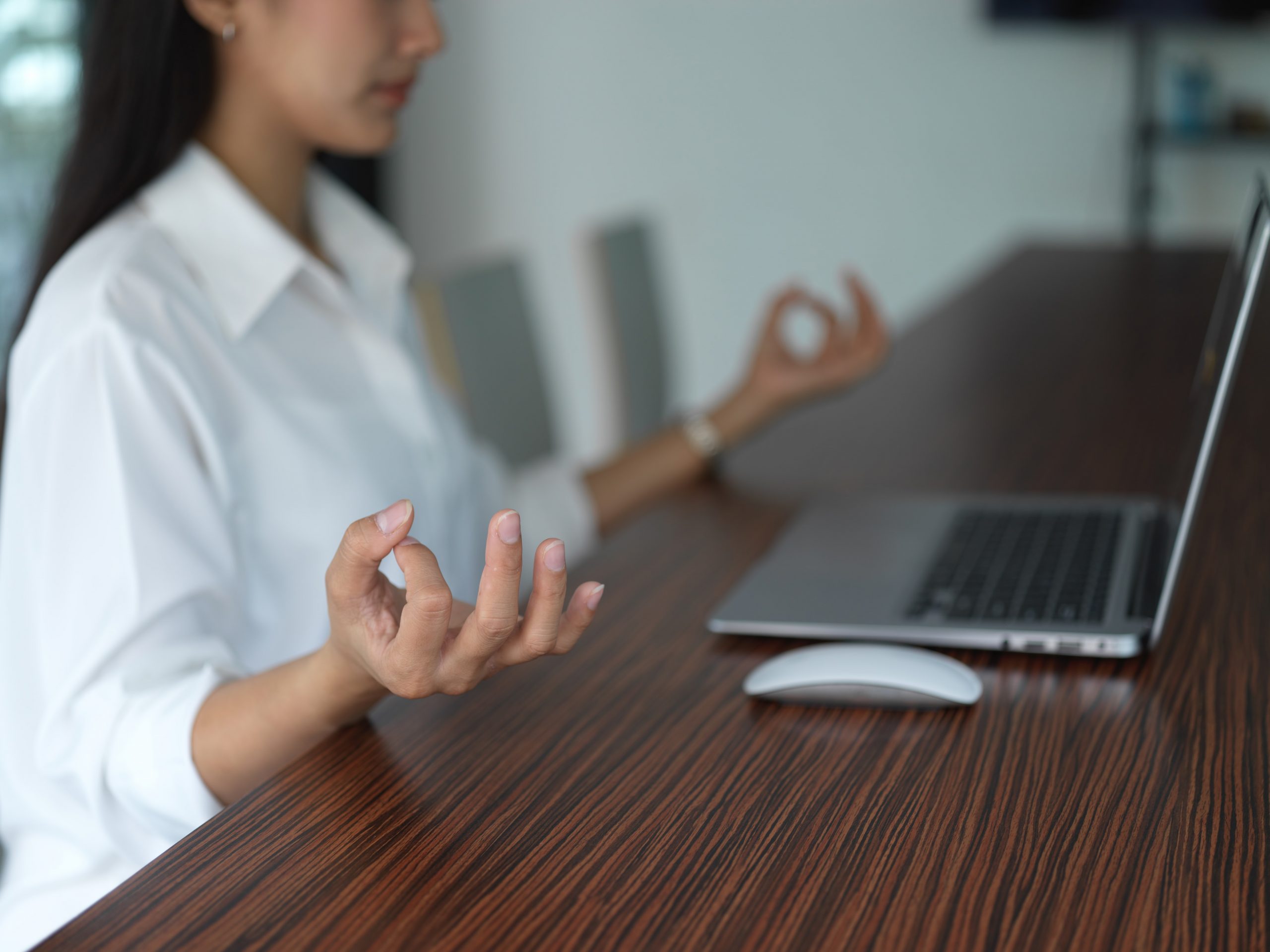 Yoga moves at the desk, stretches, woman sitting at desk practising meditation, wellbeing