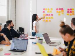 woman placing sticky notes on wall - unsplash