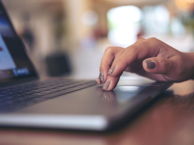 Midsection of woman using mobile phone on table